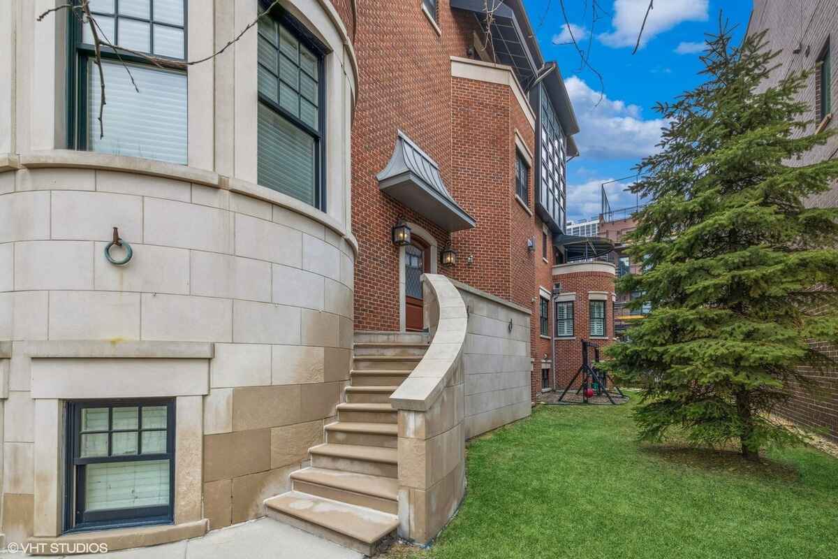 Side entrance with curved stairway and landscaped yard.