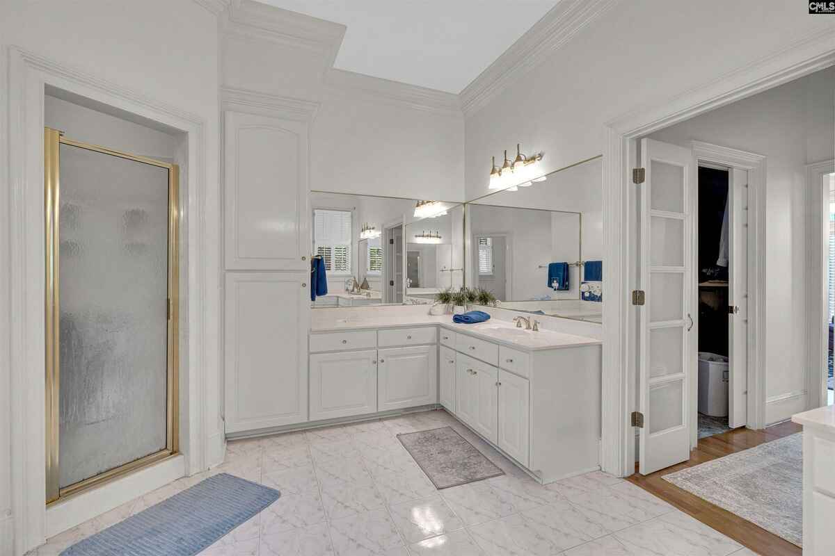 Master bathroom offers dual vanities, a walk-in shower, and ample storage space.