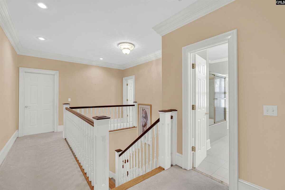 Second-floor landing displays elegant woodwork and access to multiple rooms.