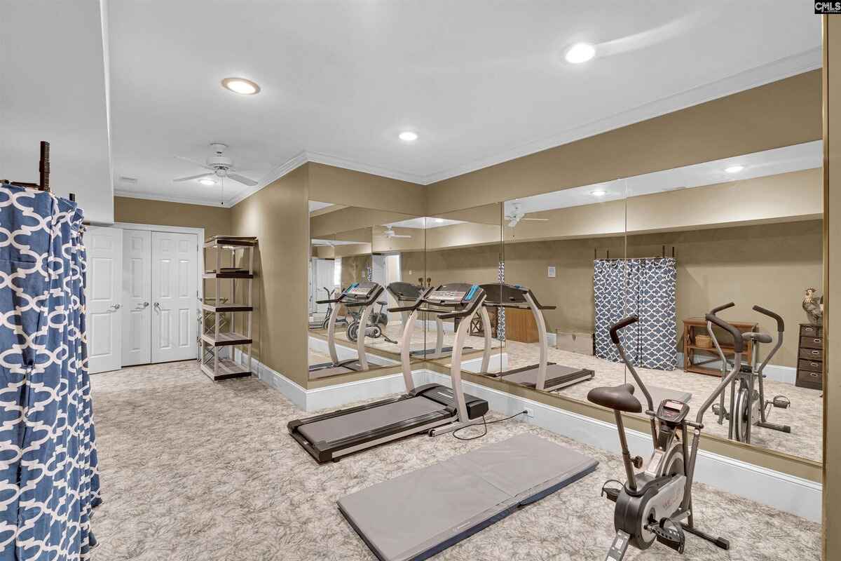 Gym space features mirrored walls, treadmills, and exercise equipment.