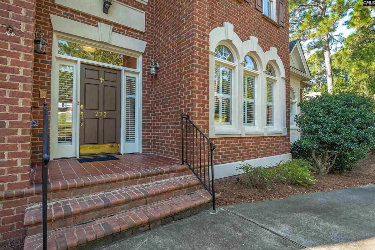 Entrance steps leading to a brown door flanked by white-trimmed windows.