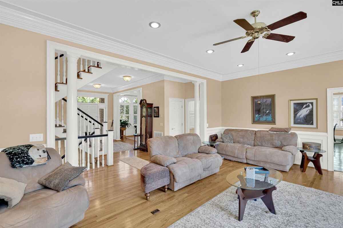 Seating area with a beige couch set in a room showcasing hardwood floors and light walls.