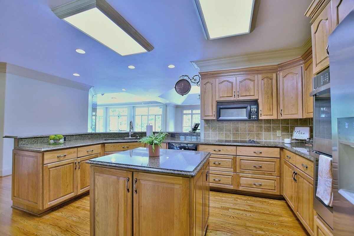 View of the kitchen extends into a bright, open space with modern appliances and large windows.