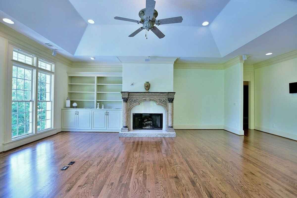 Living area includes a stone fireplace, built-in shelves, and large windows for natural lighting.