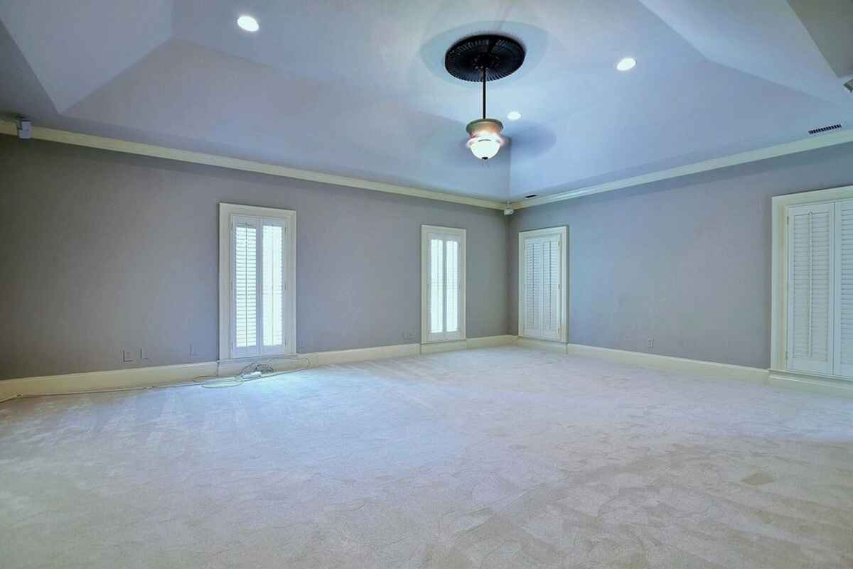 Master bedroom highlights spacious dimensions, recessed lighting, and multiple shuttered windows.