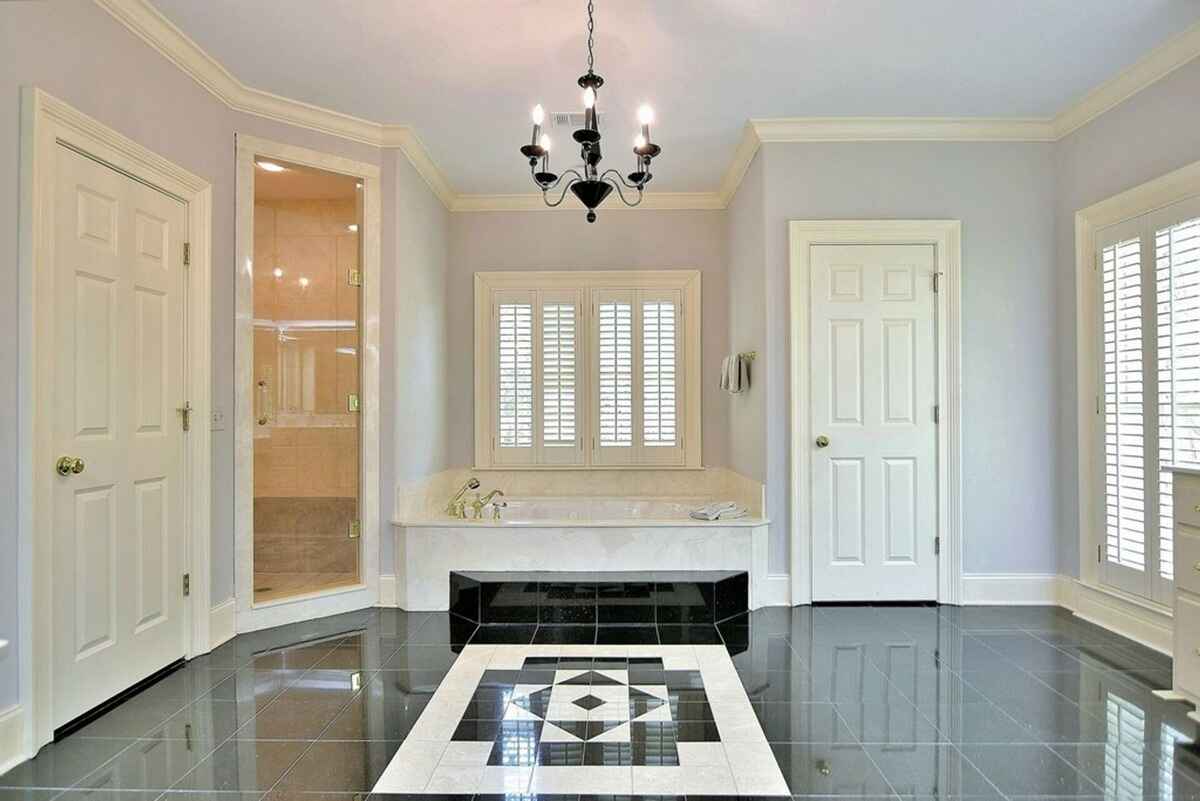 Master bathroom includes a soaking tub, walk-in shower, and glossy black-and-white tiled flooring.