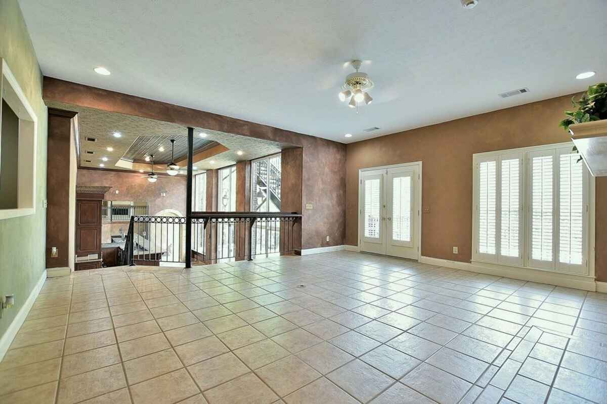 Open space overlooks a bar and living area, blending two levels with natural light.