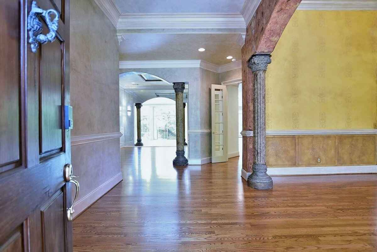 Interior entryway features hardwood floors, decorative columns, and an open view to the living space.