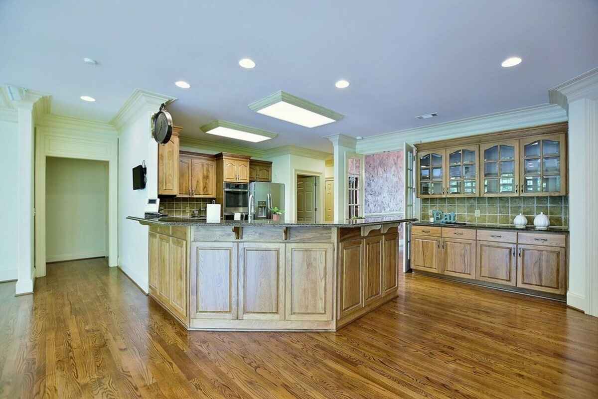 Open kitchen layout features an island, granite countertops, and ample cabinetry for storage.