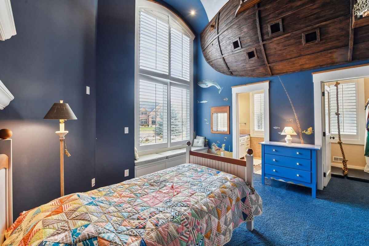 A second view of the themed bedroom showcases a ship-inspired ceiling and large windows.