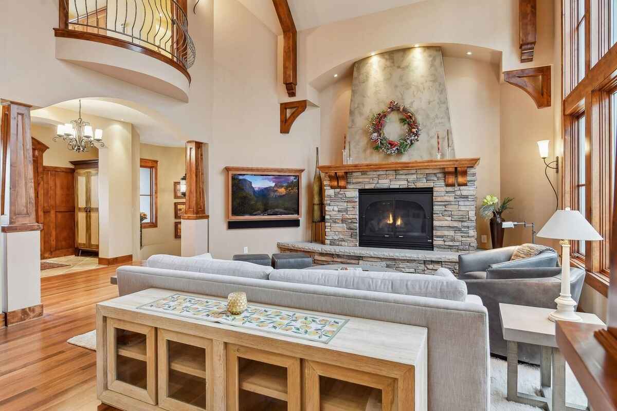 A different angle of the living room displays the fireplace, seating, and arched entryways.