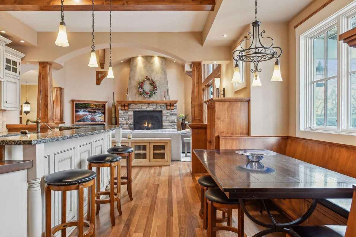 A formal dining area includes upholstered chairs, a wooden table, and a sideboard with glass doors. 