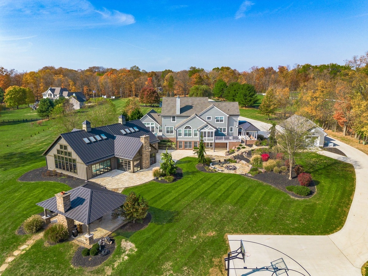 Aerial view of a large property with multiple buildings surrounded by landscaped greenery.