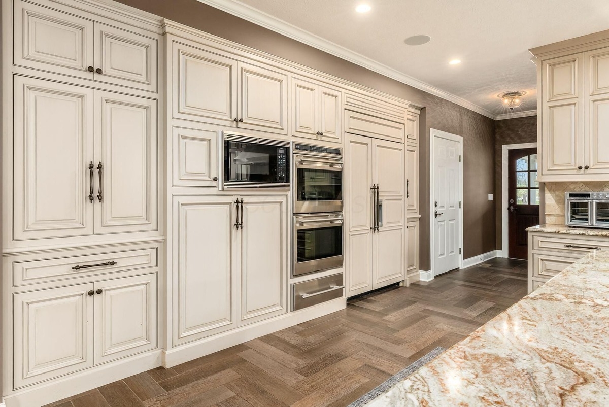 Built-in cabinetry and double wall ovens integrated into a neutral-colored kitchen design.