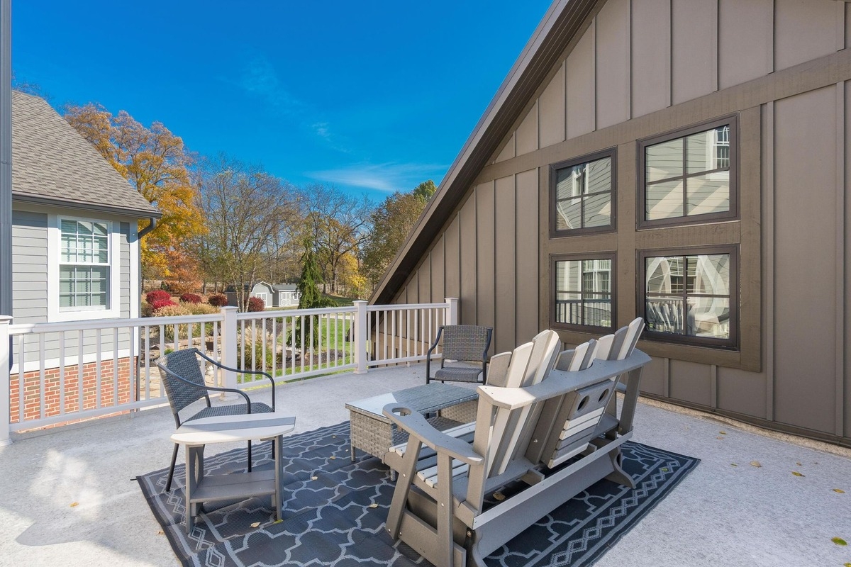 Outdoor deck with seating area and views of landscaped surroundings.