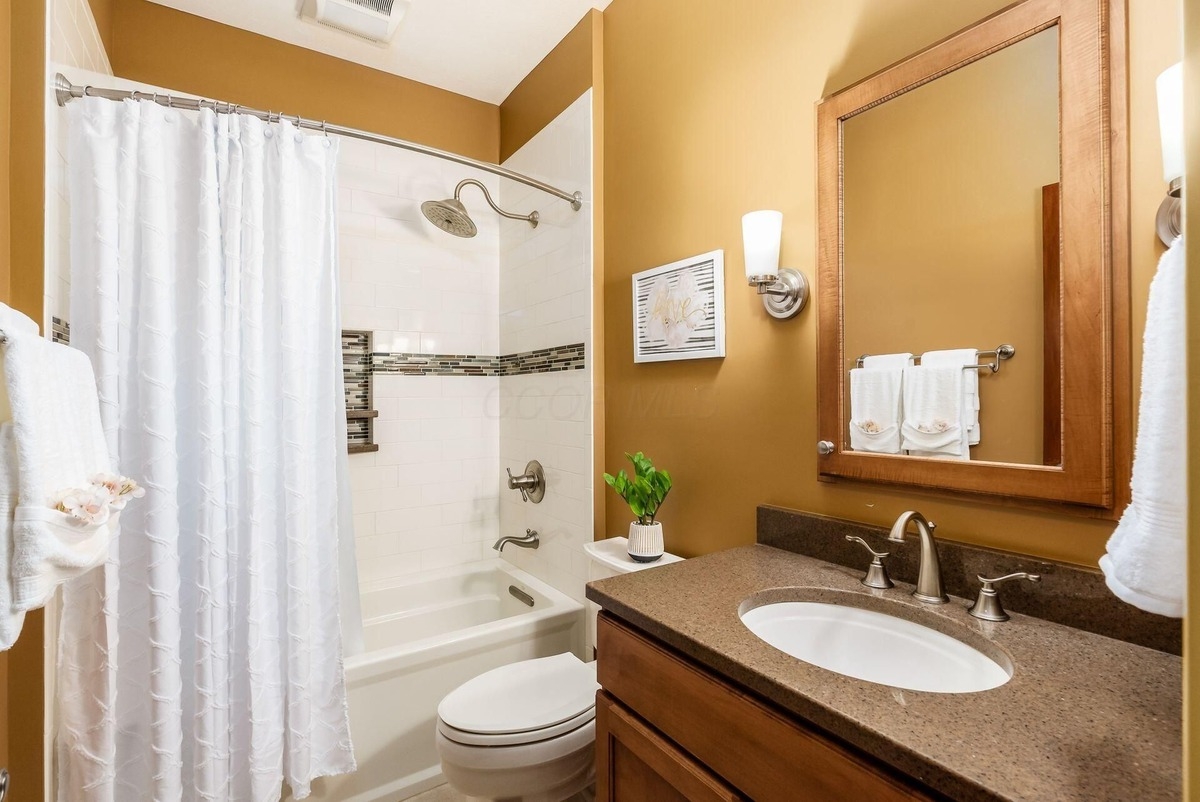 Bathroom with a tiled shower-tub combination and a modern vanity.