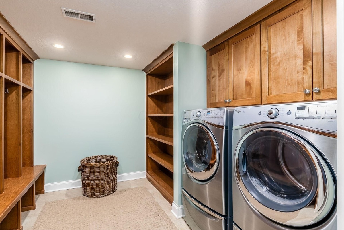 A laundry and mudroom with built-in storage, washer/dryer, and bright lighting.