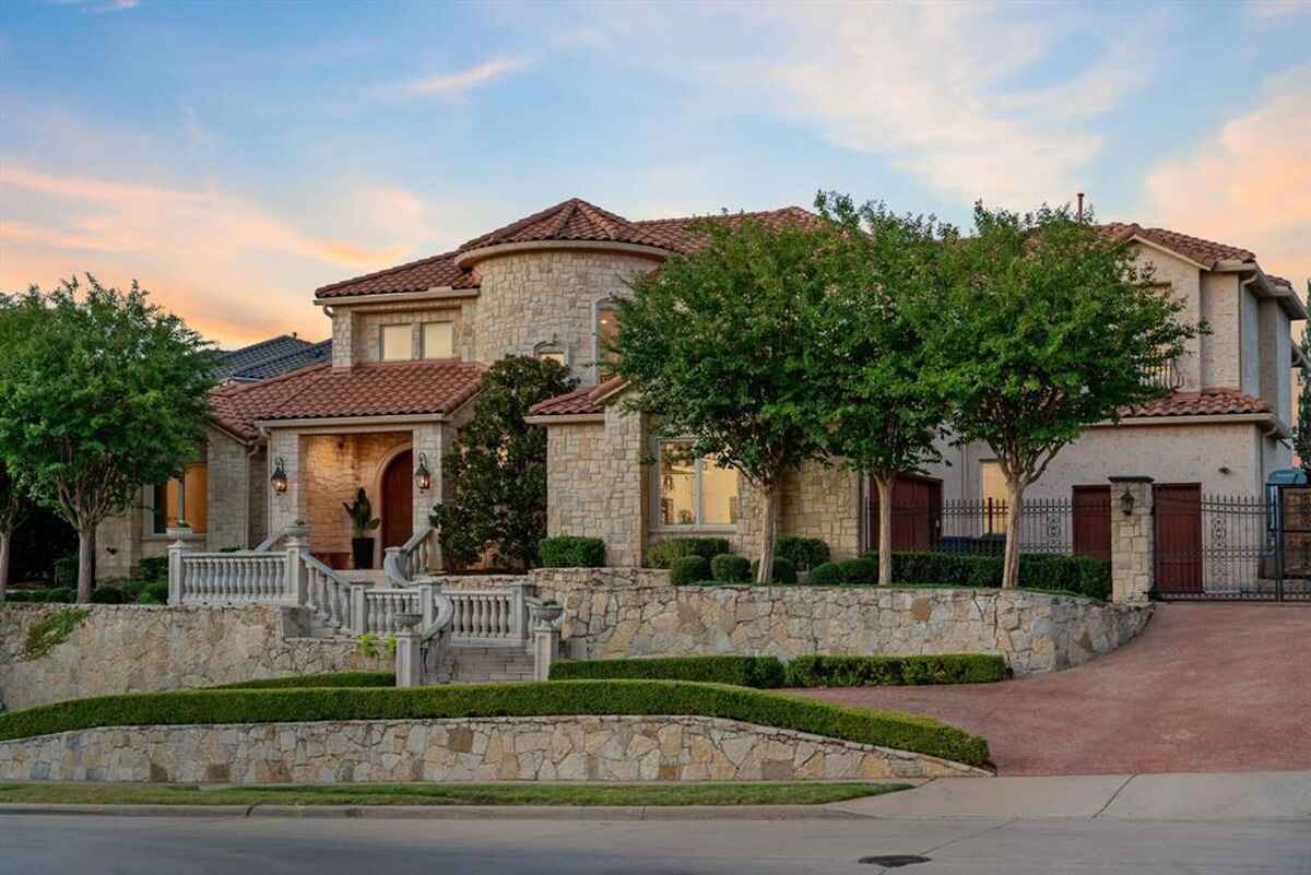 Overhead shot of a large home with tiled roof, pool, and landscaped yard.