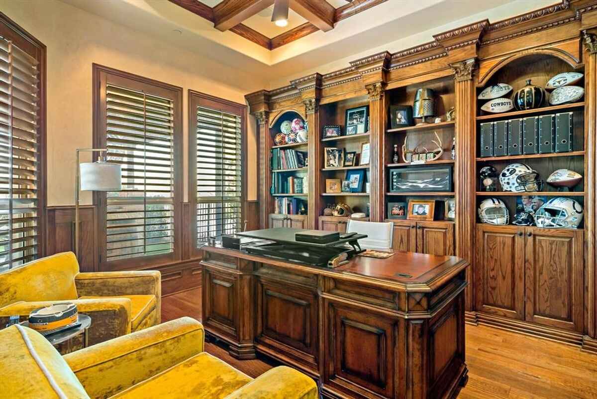 Traditional home office with built-in wooden shelves and classic furnishings.