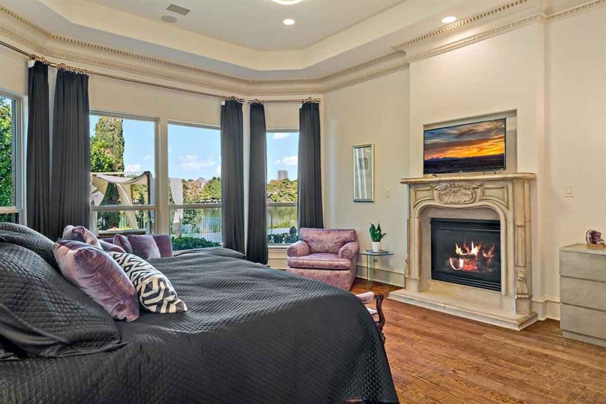 Master bedroom with a fireplace, sitting area, and scenic views.