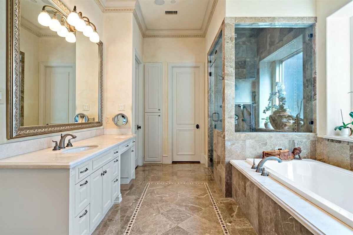 Luxurious master bathroom with marble finishes and a soaking tub.