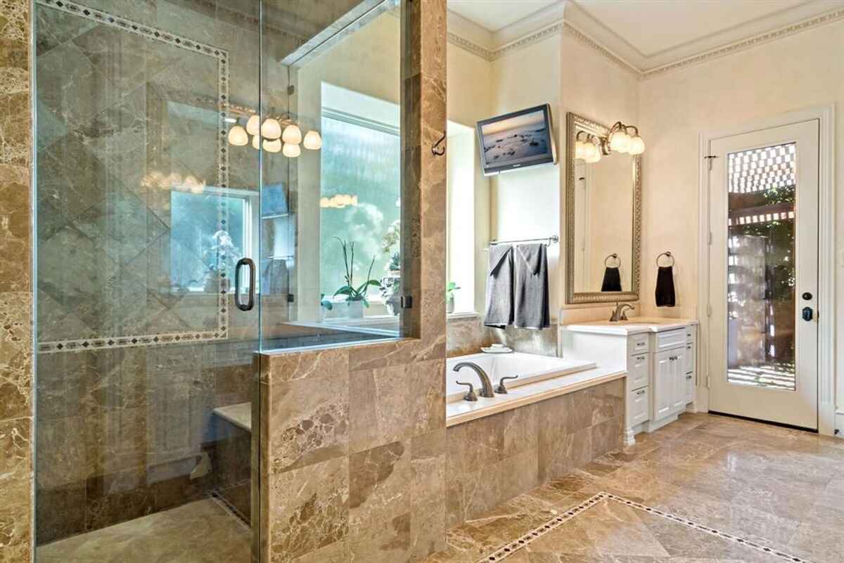 Additional view of the master bathroom, featuring a glass shower and double vanities.