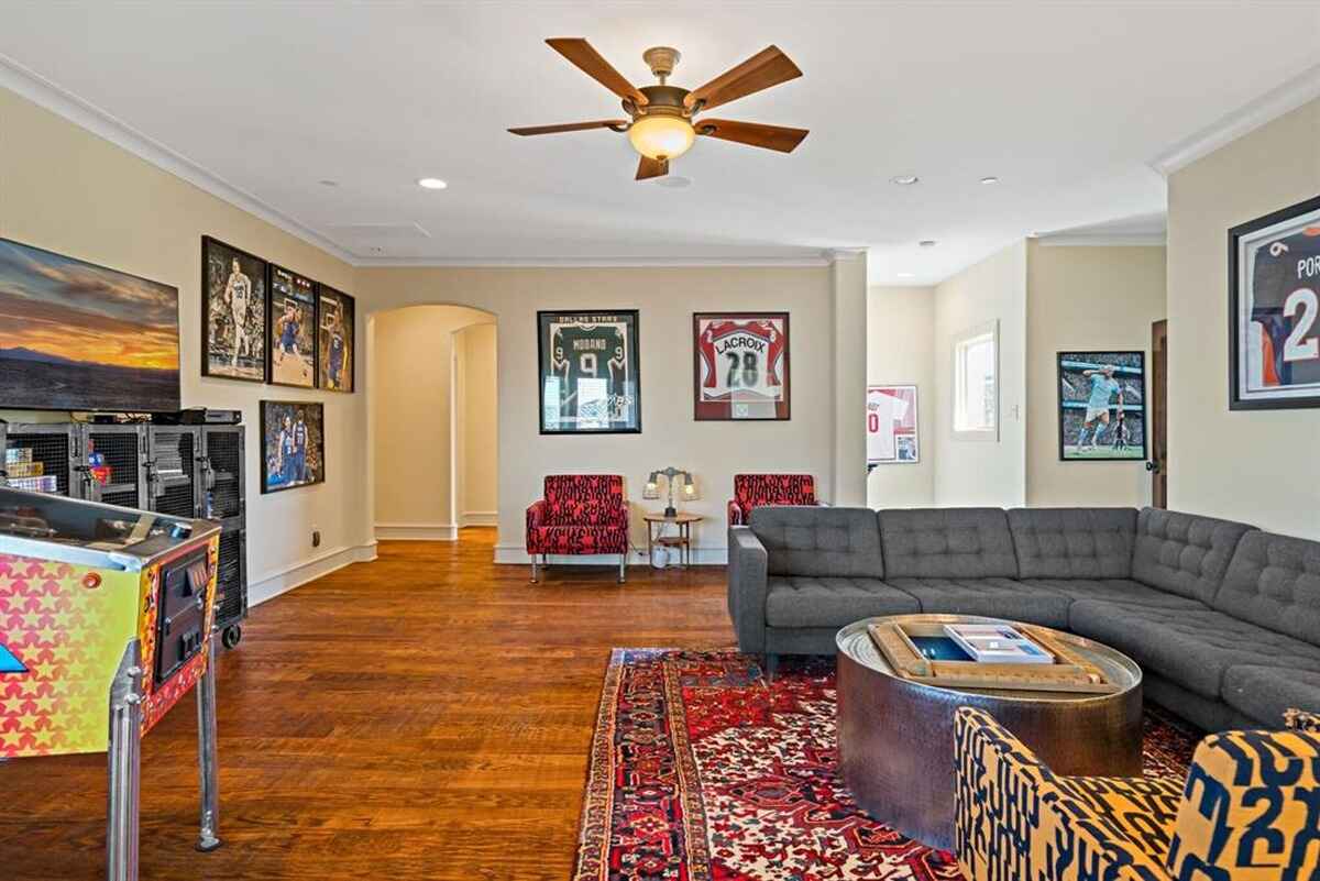 Recreational room displaying sports memorabilia, a sectional sofa, and lounge chairs.