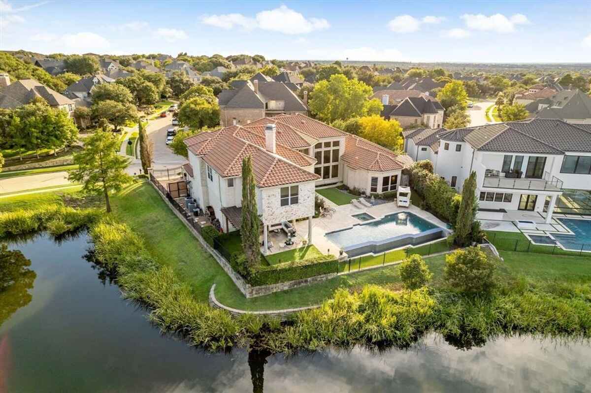 Aerial view of the home showing the backyard, pool, and lakefront location.