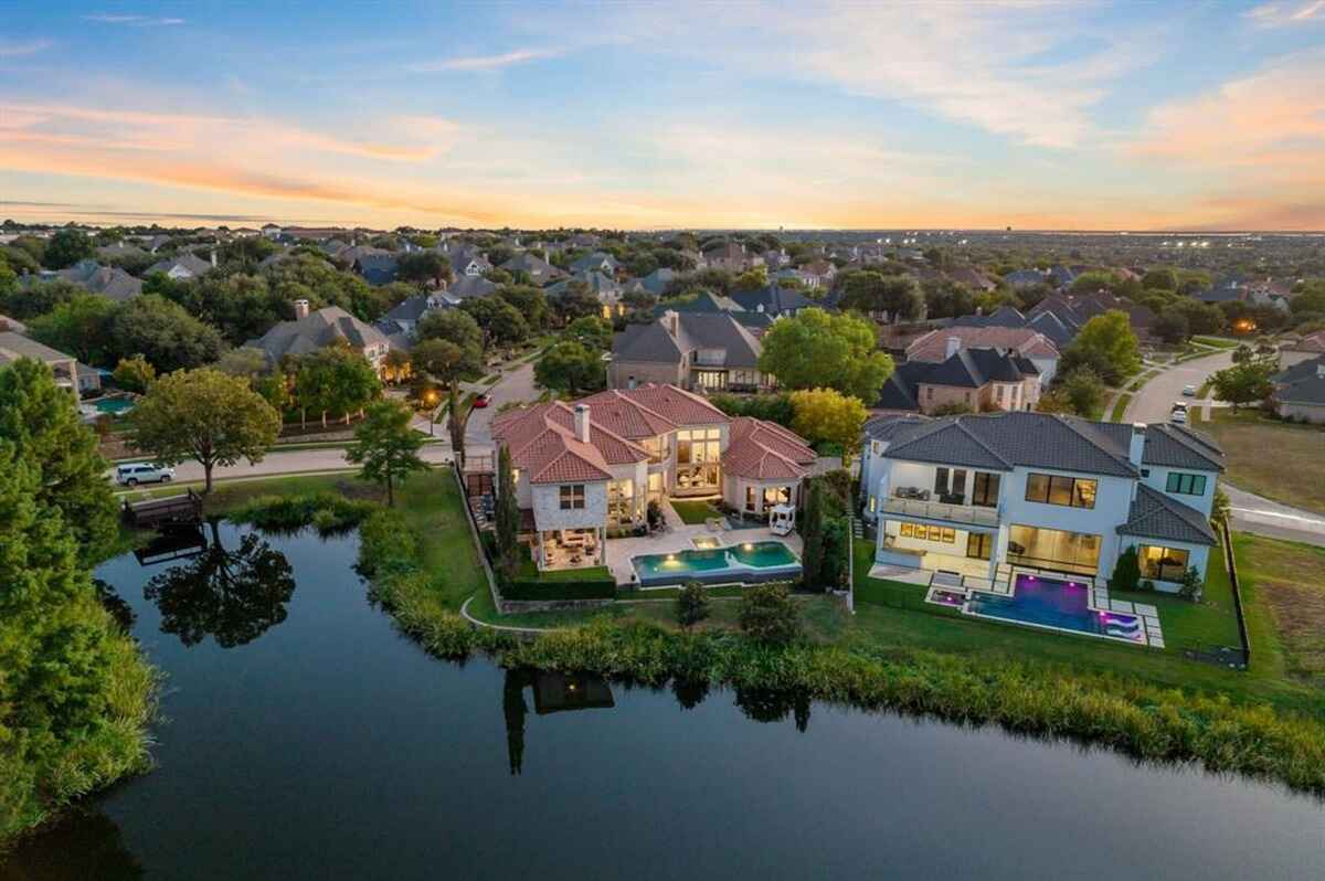 Evening aerial view of the home and its surroundings, highlighting neighborhood and lake views.