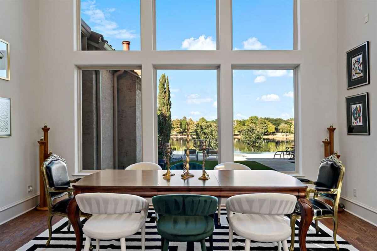 A dining area with a view of the lake through tall windows.