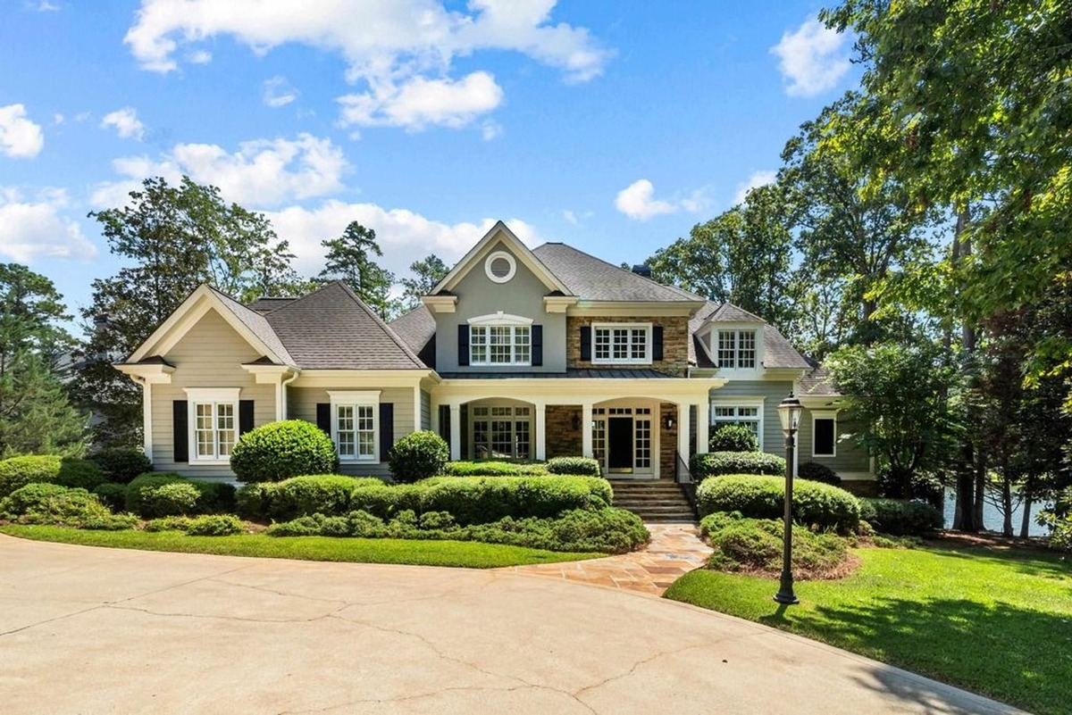 Elegant two-story home with a well-manicured landscape and a circular driveway.