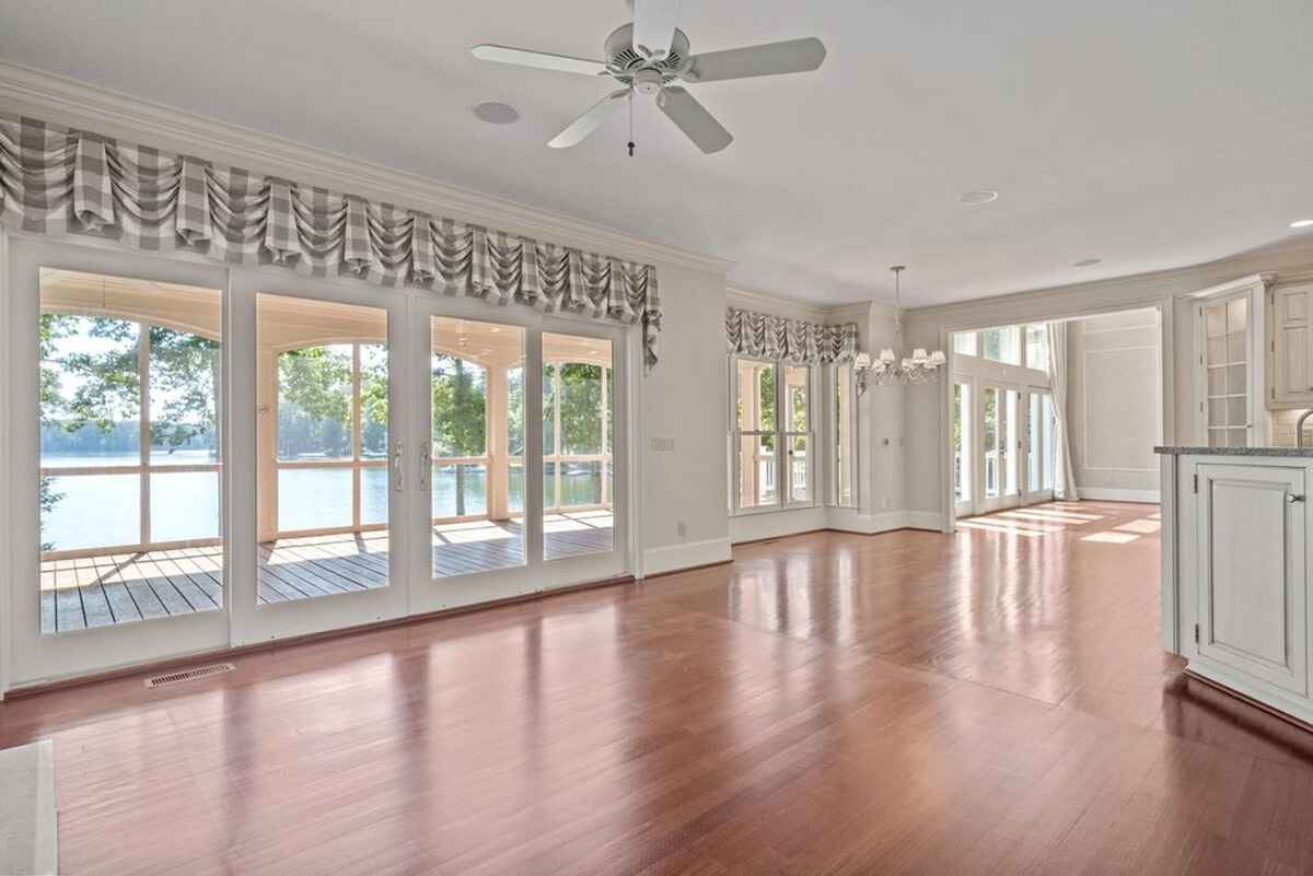 Living area showcases floor-to-ceiling windows providing natural light and views of the outdoor deck and water.