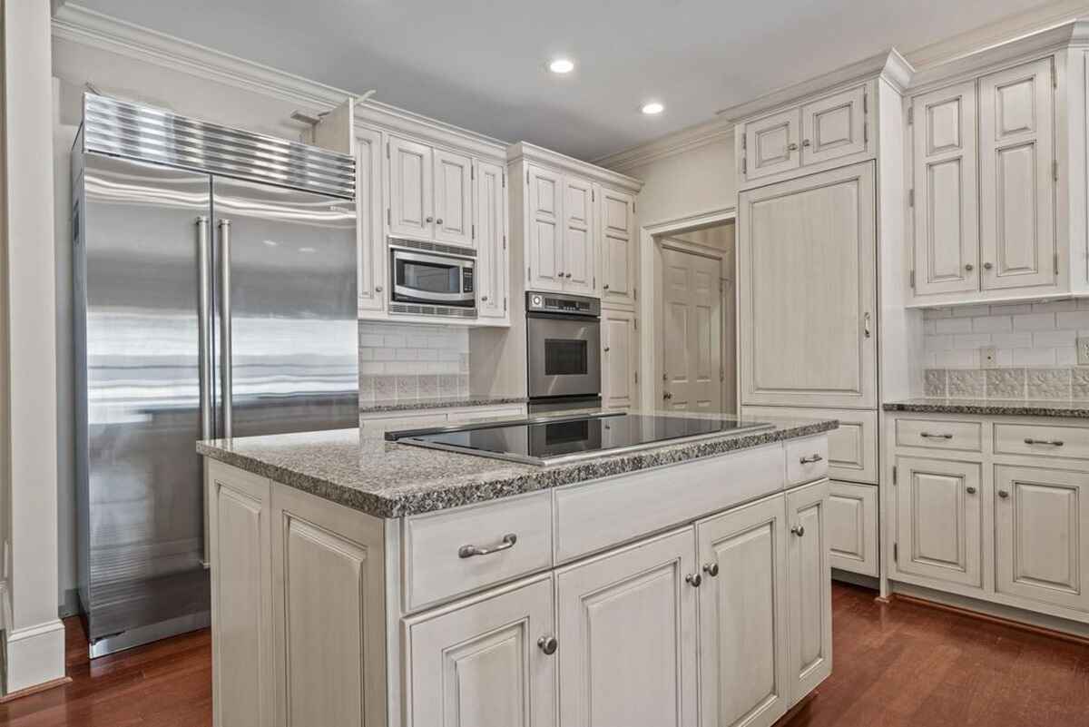 Kitchen highlights stainless steel appliances, ample storage, and a combination of modern and traditional design elements.