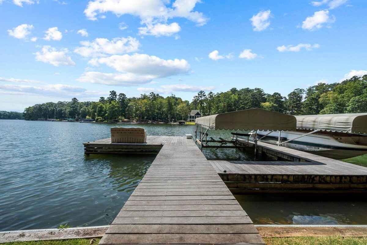 Private dock extends into the lake with covered boat storage and serene water views.