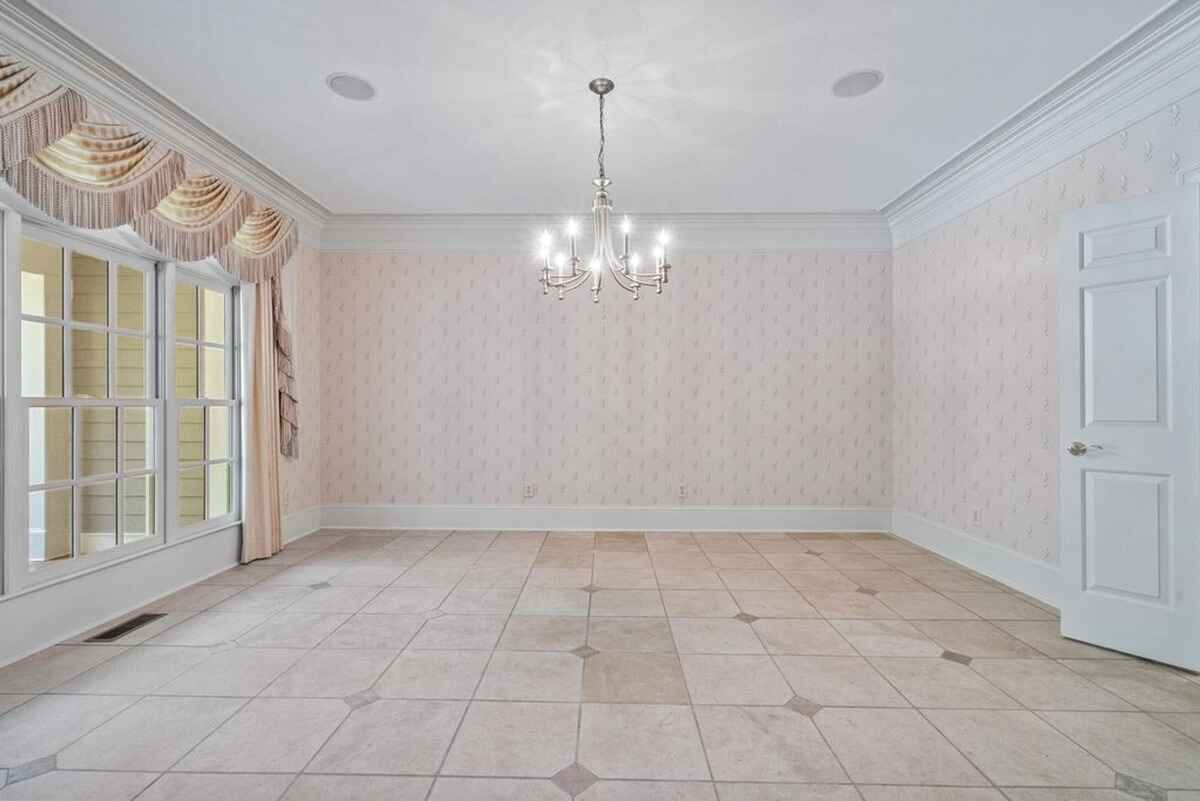 Formal dining room featuring a chandelier, large windows, and detailed crown molding.