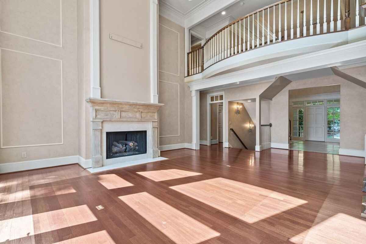 Living room with hardwood floors, a fireplace, and a second-floor balcony.