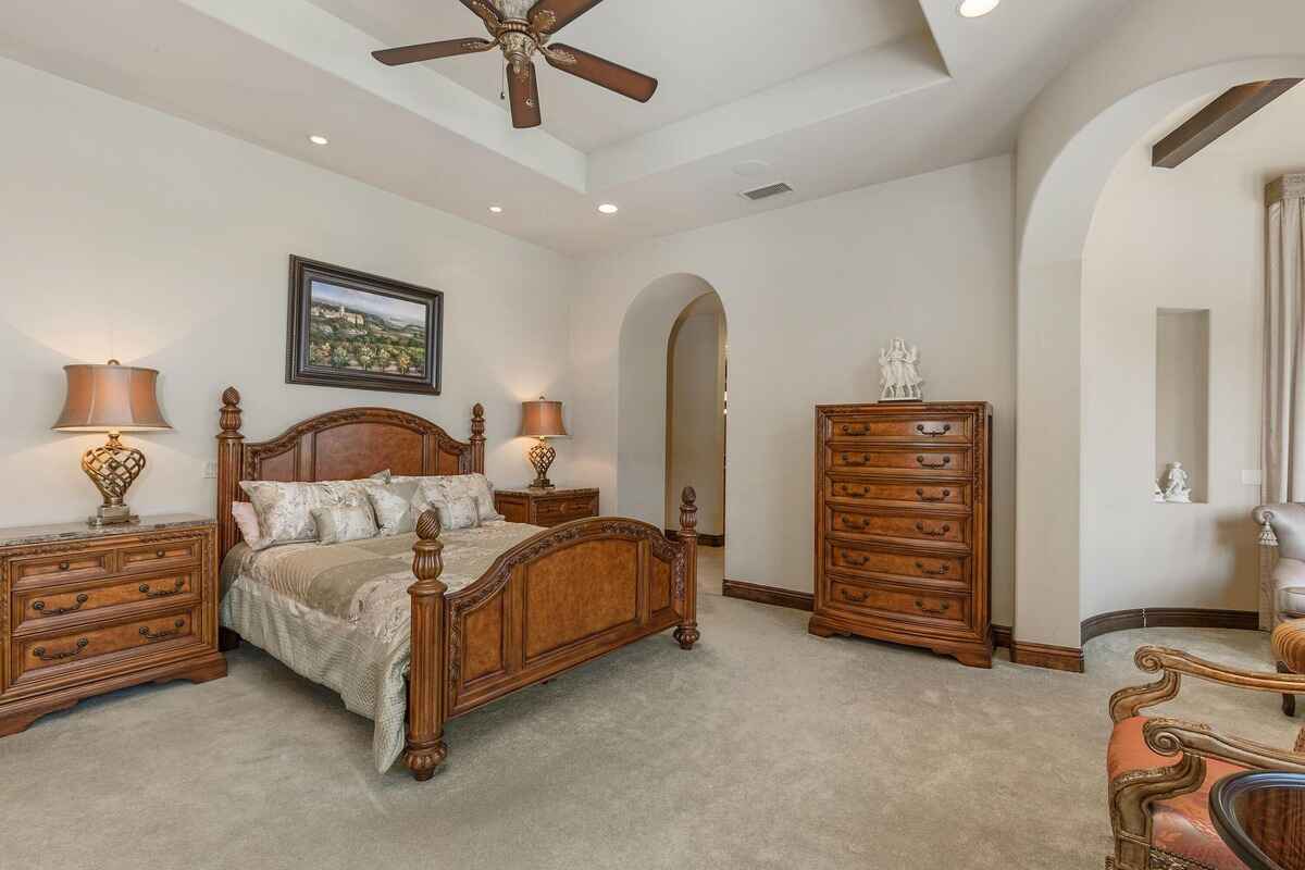 Bedroom featuring a wooden bed frame, matching dressers, and soft lighting from table lamps.