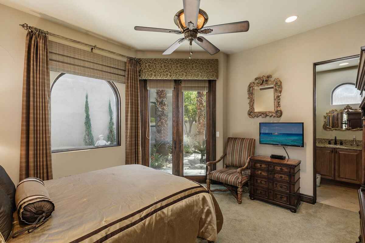 Guest bedroom with large windows, a seating area, and direct access to the garden.