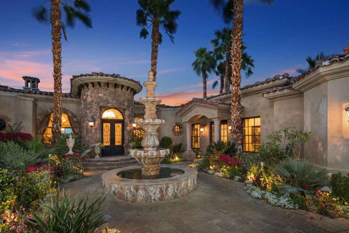 Central courtyard featuring a grand stone fountain surrounded by well-maintained greenery.