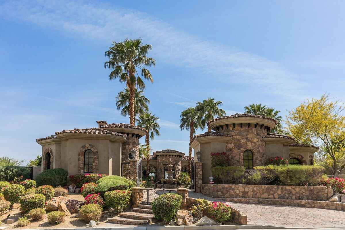 Front exterior view of the home showcasing stone architecture, landscaped gardens, and a welcoming entrance.