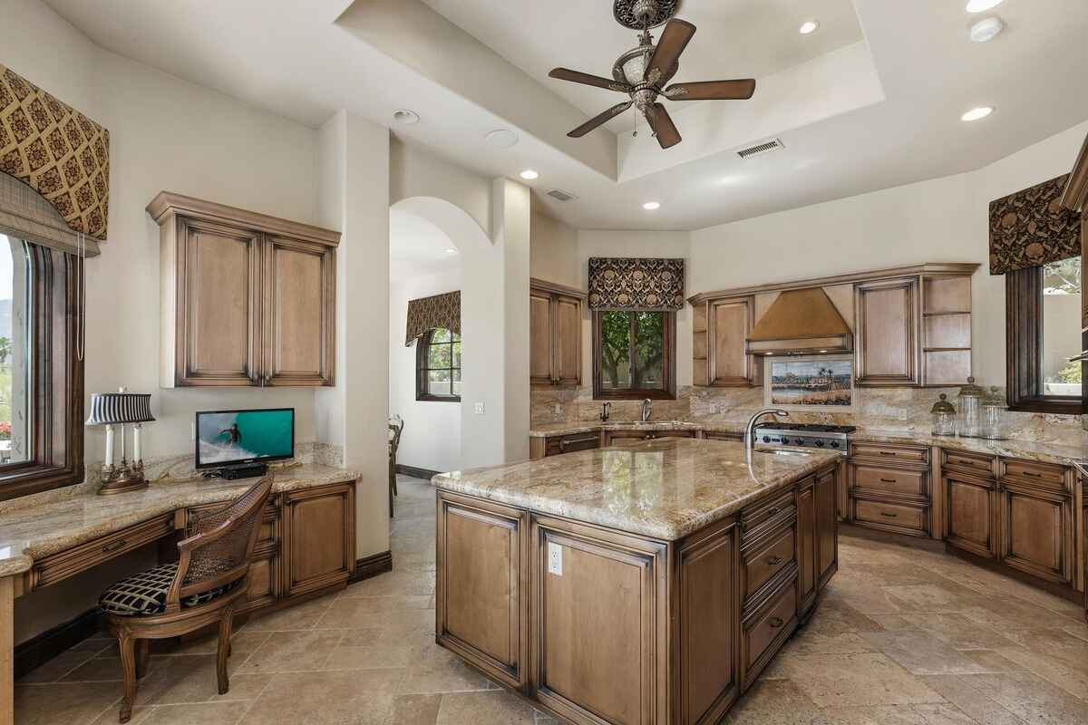 Kitchen with wooden cabinetry, granite countertops, and large central island.