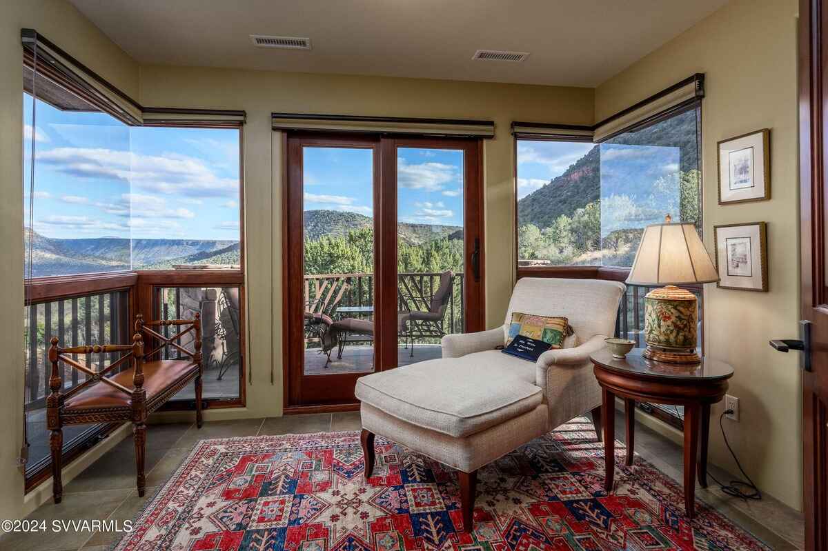 Small room with a chaise lounge, large windows, and access to an outdoor deck.