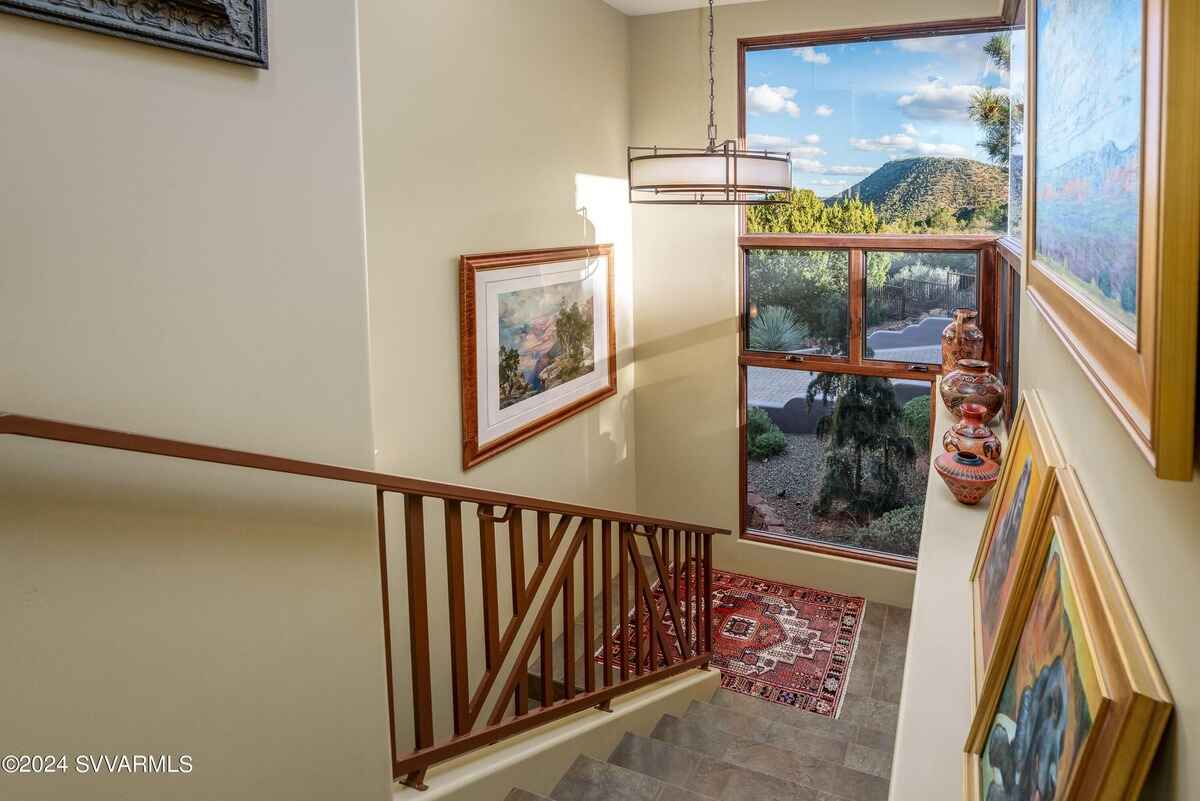 A staircase with large windows, natural light, and framed artwork along the walls.