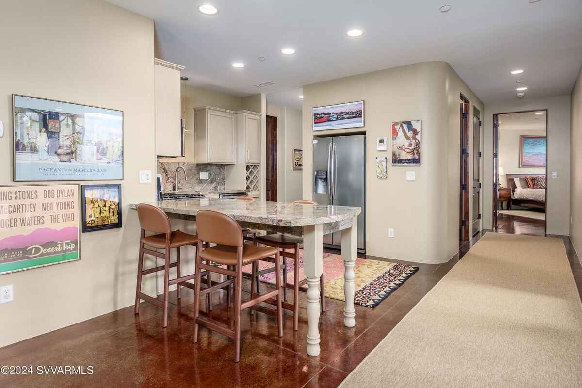 Kitchenette with a small dining area, marble countertops, and a compact refrigerator.