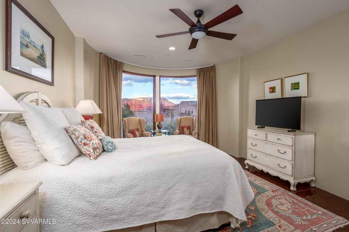 A bedroom with a serene view of red rock formations through expansive windows.