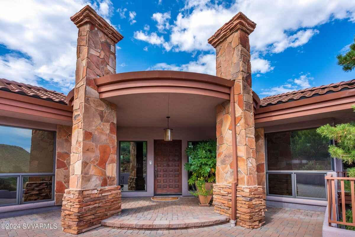 A grand front entrance with stone columns and a curved portico.