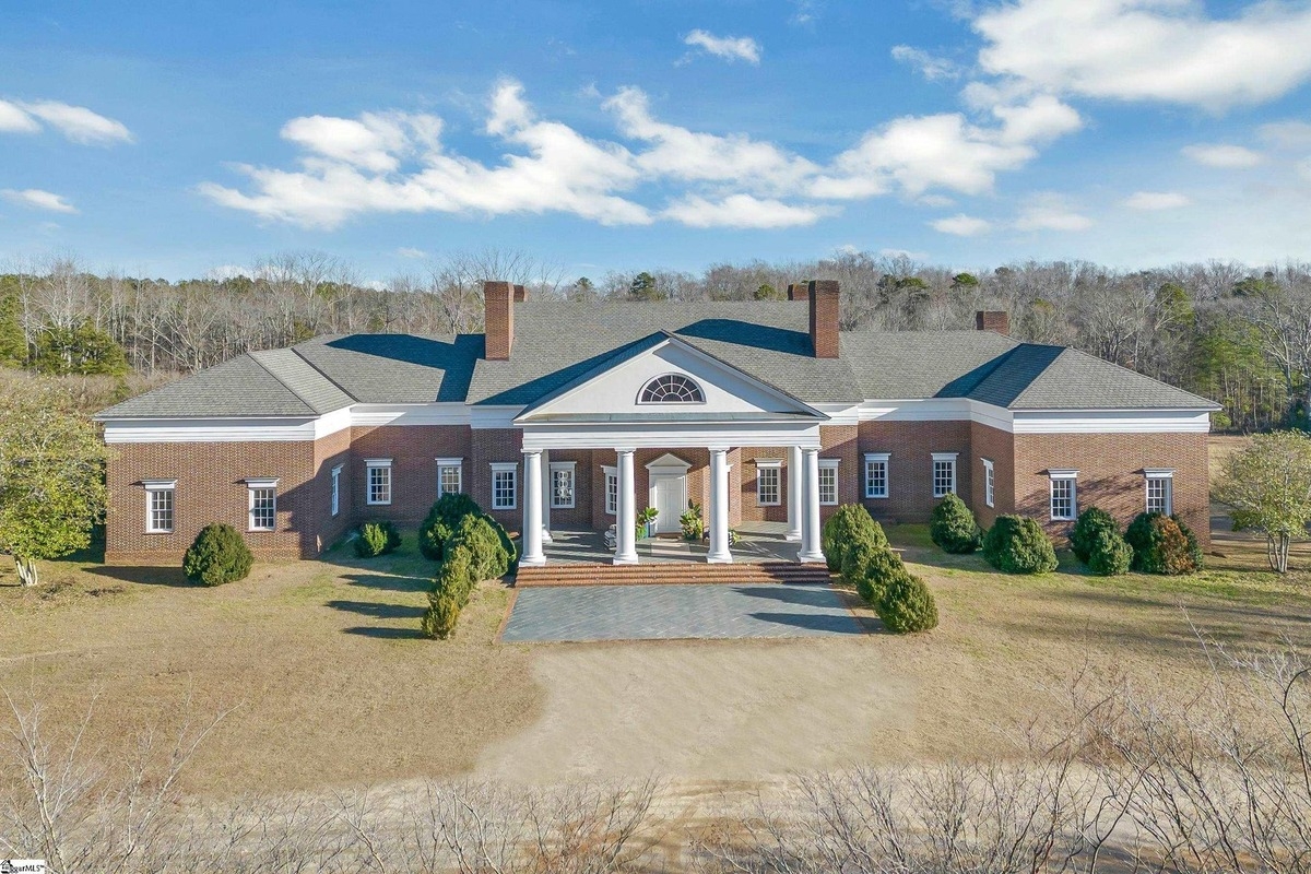 Stately front elevation featuring white columns and classic brick design.