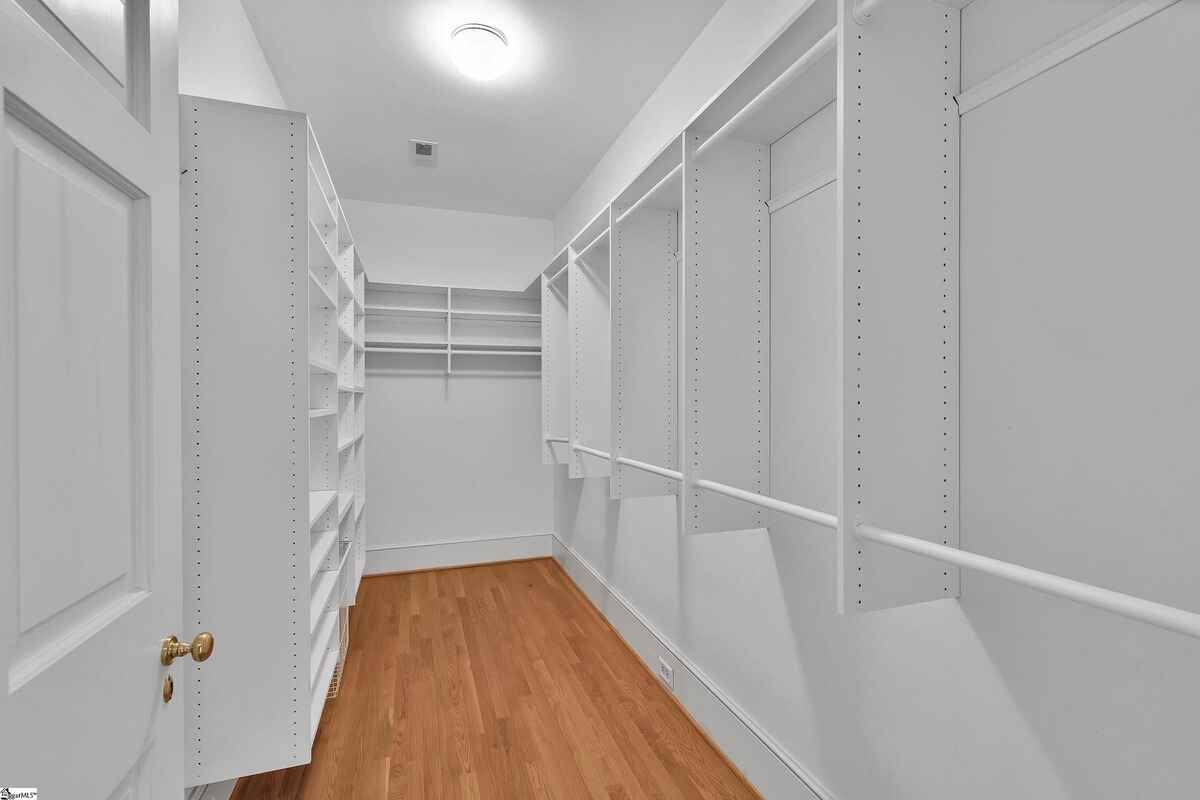 Walk-in closet with ample shelving and hanging space.