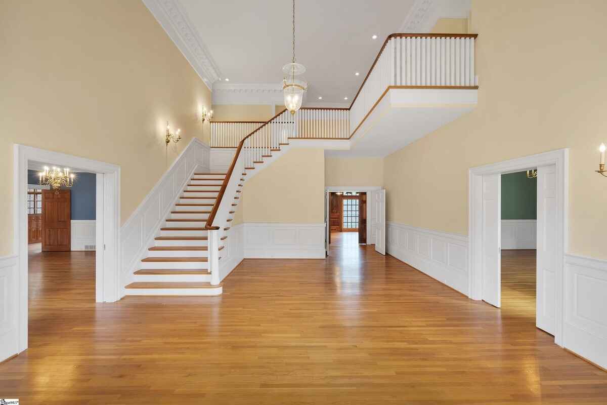 Spacious foyer with a sweeping staircase and elegant high ceilings.