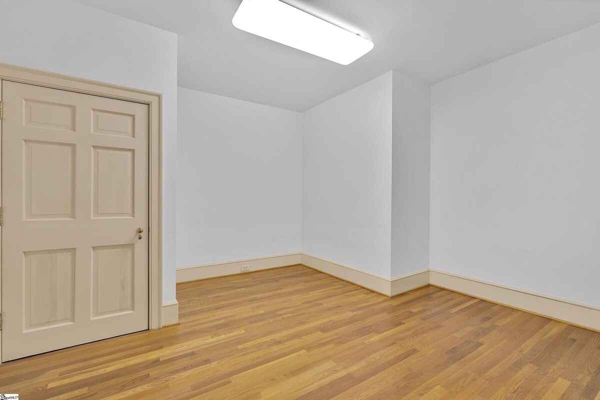 Smaller adjacent room featuring hardwood flooring and simple trim details.